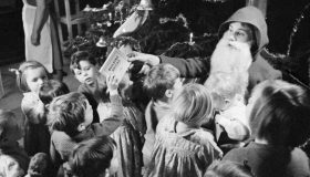 Santa Claus hands out presents to children in the 1940s.